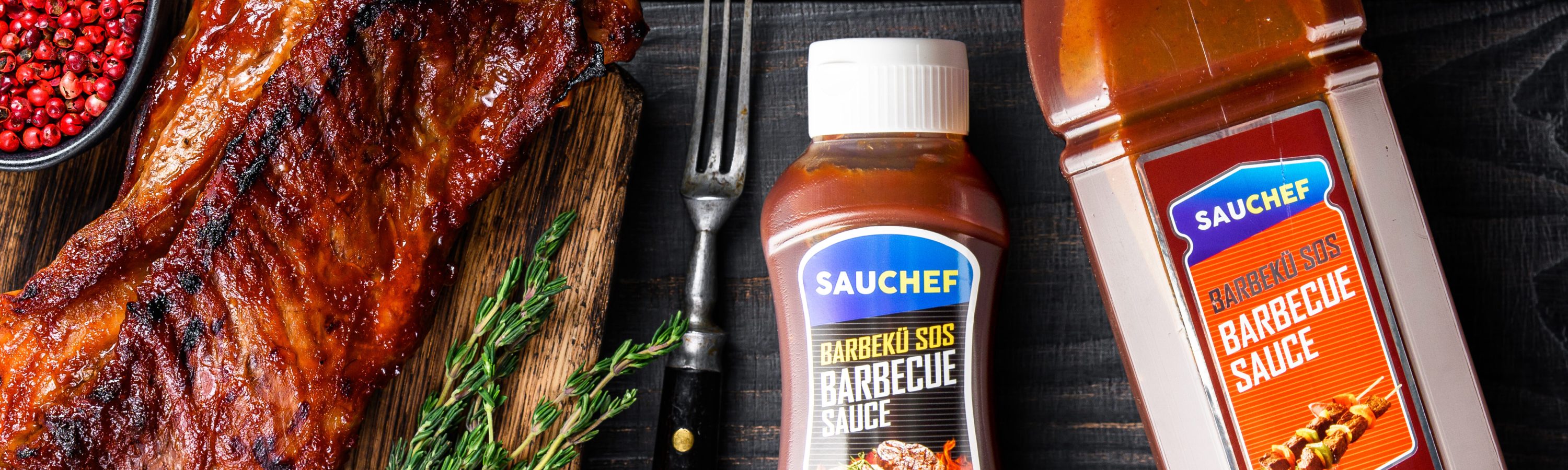 Grilled in bbq sauce veal short spare rib meat on wooden cutting board. Black wooden background. Top view. Copy space.